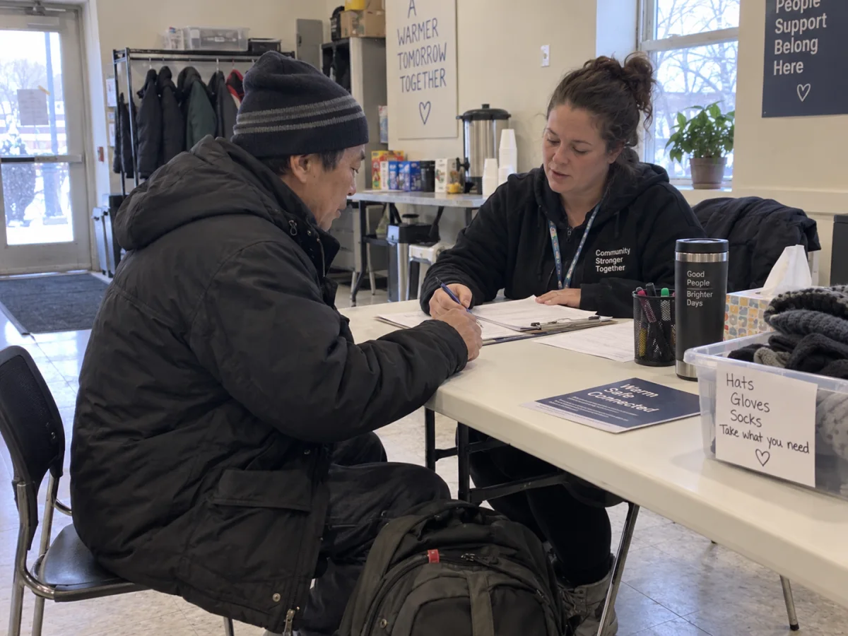 A staff member helping a guest complete intake paperwork.