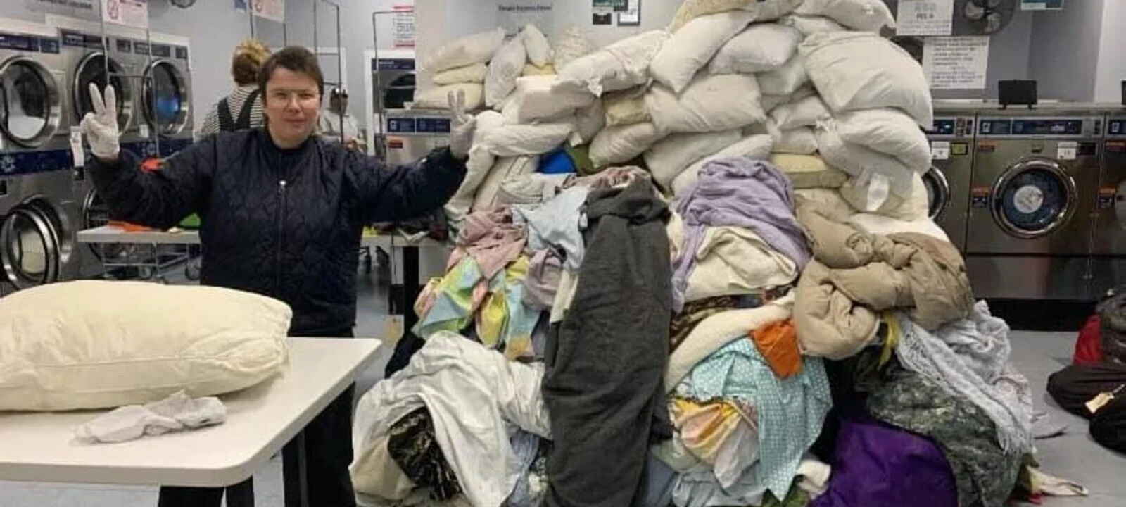 A volunteer alongside freshly washed shelter bedding.